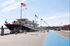Yacht docked and ready for the Media.net celebration, lined with American flags along the pier under a clear sky.