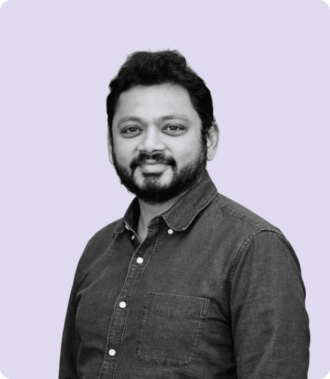 Black-and-white portrait of Karan Dalal, COO of Media.net, appearing approachable and professional, wearing a button-down shirt, against a gentle lavender-colored background.